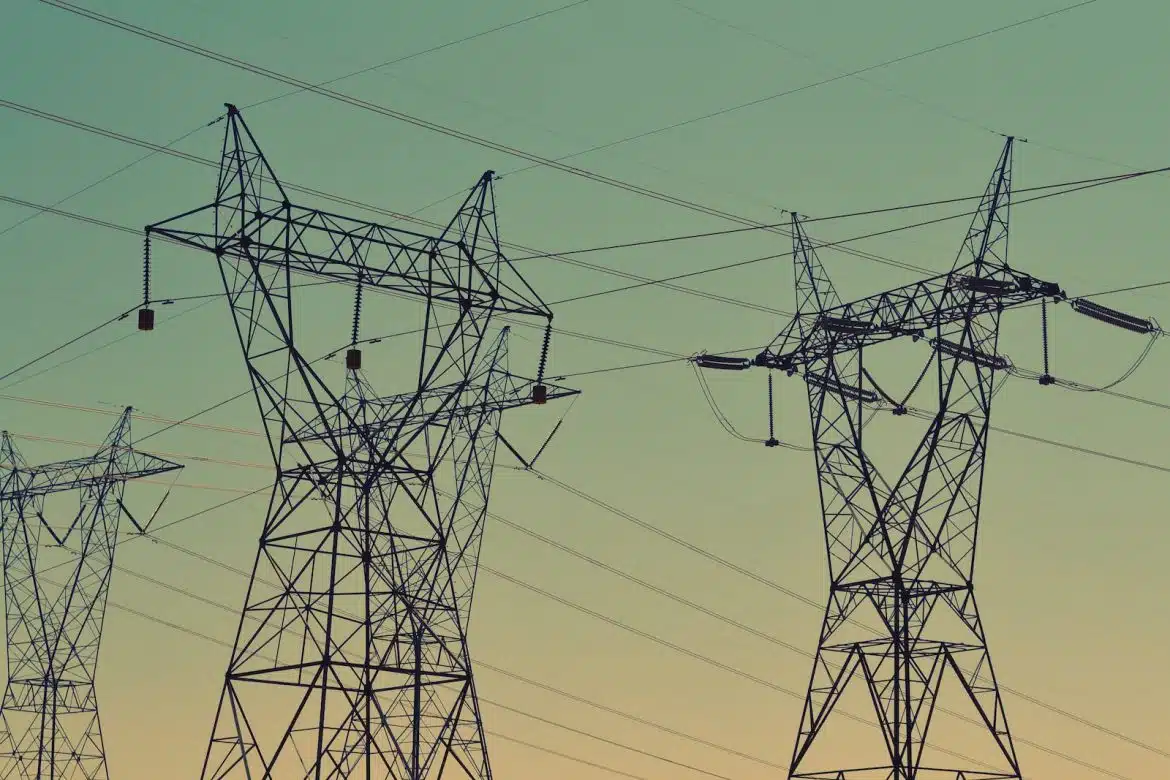 black transmission towers under green sky